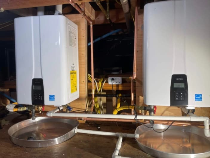 Twin tankless water heaters installed with drain pans in a Santa Rosa crawlspace